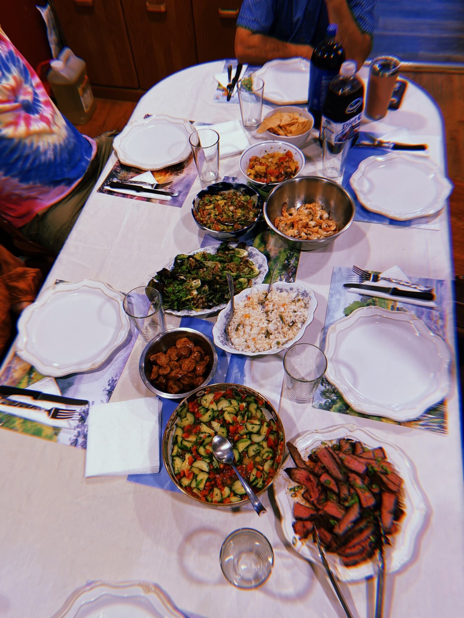 Family-style table spread with shrimp, steak, salads, and rice